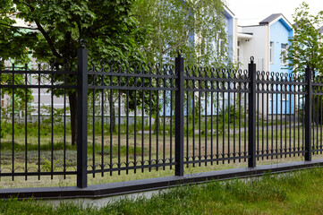 Metal fence in the city park. Decorative black iron guardrail for protection, close up
