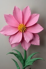 Handcrafted Pink Paper Flower with Yellow Center on Grey Background