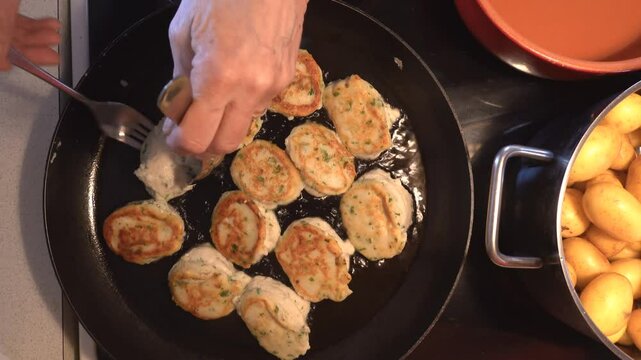 Hirtshals Denmark Fish frikadeller or fish balls, a Danish food speciality, frying in a pan.