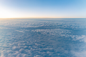 Beautiful orange and pink sunrise over the clouds, view from the plane.