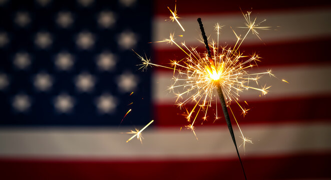 A sparkler burning brightly in front of a blurred american flag creating a festive atmosphere - Powered by Adobe