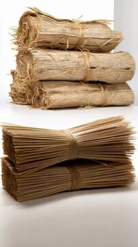 Stacks of bundled raffia fiber tied with string on a white background ready for crafting and creative uses