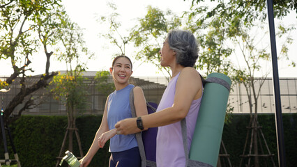 Young adult child and mature middle age old mum public park walk workout with yoga mat water...
