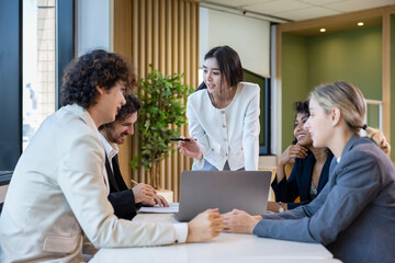 Asian woman sale manager is showing annual report to her colleague in executive meeting for next year plan with market share increase for global business and investment