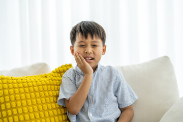 Young child experiencing toothache, tooth decay, childhood dental pain. The child facial...