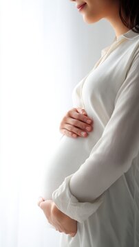 Pregnant woman holding belly in soft light	