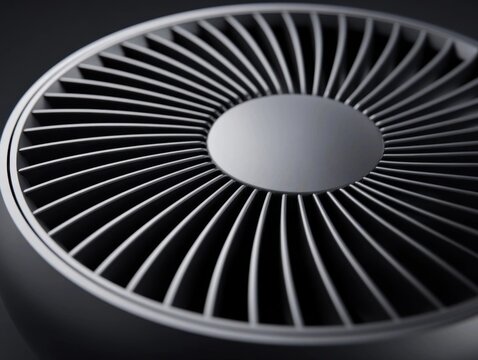Close-up of a dark gray circular vent with radiating fins, resembling a turbine or fan, on a dark background.