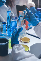 Scientist pipetting medical samples into microplate in laboratory