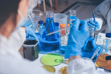 Scientist pipetting medical samples into microplate in laboratory