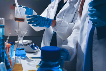 Scientist pipetting medical samples into microplate in laboratory