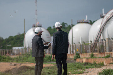 Environmental engineer manager examining waste water along large industrial construction waste...