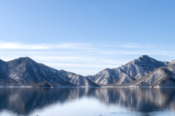 Landscape scenery of snow mountain at Lake Chuzenji in winter with reflection on water surface
