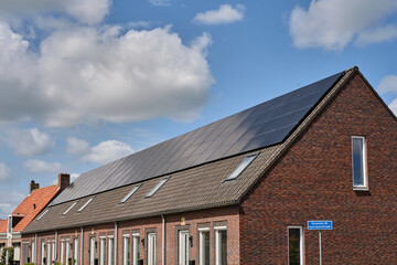 Modern Dutch housing block with shared solar panel rooftop in Oosterland