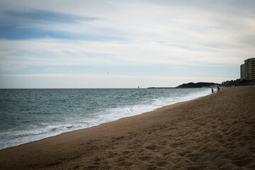 Footsteps on the sand in the shore of a beach with quiet waters in Costa Brava