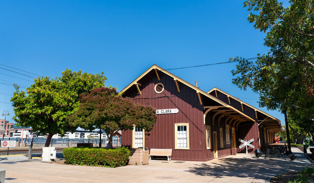 Santa Clara, California - May 23, 2025: Santa Clara Train Station and Transit Center, viewed under a bright blue sky with surrounding trees and platform shadows creating a calm urban atmosphere.