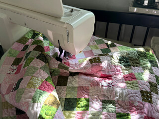 Patchwork Quilt in Sewing Machine. Free-Motion Quilting Concept. Handmade Mobile Photo, Selective Focus, Sunlight, Not AI