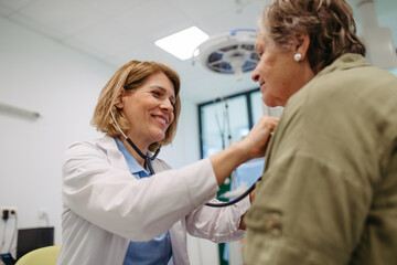 Geriatrician doctor examining elderly patient with stethoscope.