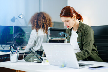 Two female fintech developers collaborating on finance apps, data analytics, and UI UX design in a...
