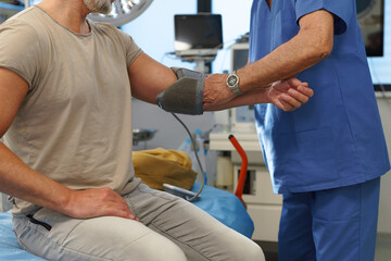 Doctor taking patient's blood pressure using digital blood pressure monitor.