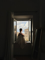 Person Sitting by Open Window with Scenic View