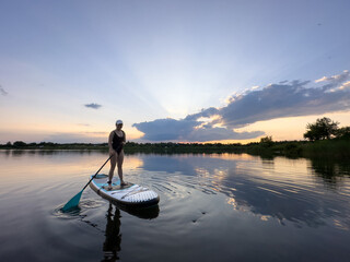 Paddleboarding at Sunset on a Tranquil Lake