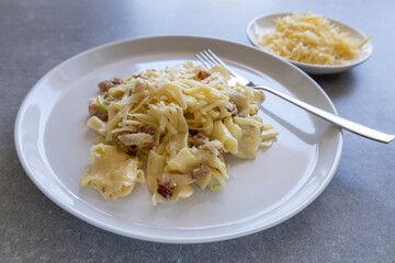 side view of creamy zucchini pasta with grated cheese and fork