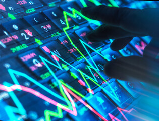 Hand interacting with stock market data on a digital screen