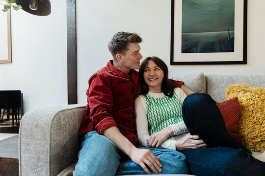 Couple relaxing on a sofa at home showing affection and togetherness