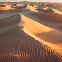 A professional, ultra-realistic aerial photograph of a desert landscape at golden hour, capturing natural sand dune patterns and soft wind-carved ripples in golden-orange hues. 
