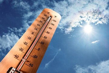 Thermometer showing tropical heat and sky with hot sun rays in Celsius and Fahrenheit