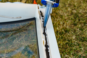 Applying silicon on caravan sunroof