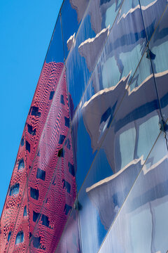 Glass reflections of vibrant architecture, geometric lines and patterns, urban skyline and blue sky, creative architectural design, modern construction details.