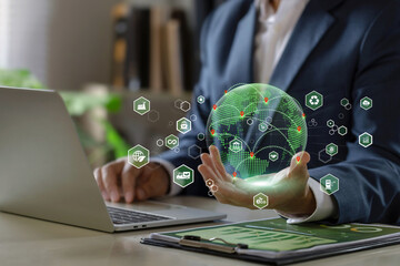 Green Logistics concept. businessman holding a green world with Clean energy transportation icons.Sustainable logistics. Environmentally friendly transportation of goods.Economic trade, import, export