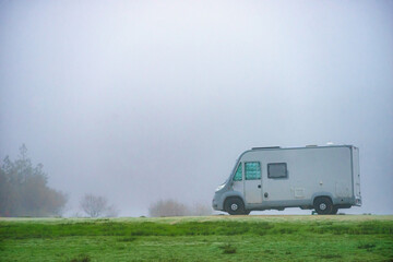 Camper rv camping on nature. Foggy day