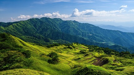Fototapeta premium The wide-angle lens captures the lush meadows stretching out into the mountains in the distance under a clear sky, a picturesque natural landscape that is perfect for travel media.