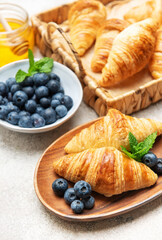 Delicious french croissants with fresh blueberries and honey for breakfast