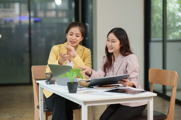 Two Asian businesswomen have a meeting in the office.