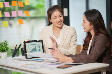 Two Asian businesswomen have a meeting in the office.