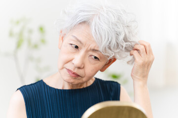 ヘアケアをするシニア女性　ビューティイメージ.