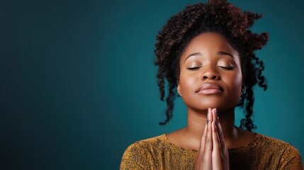 A serene woman with closed eyes and folded hands reflects a peaceful aura, embodying tranquility and mindfulness in a calming blue environment.
