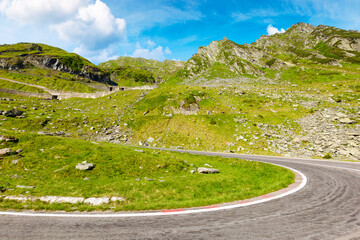 romania travel landscape with road in summer. spectacular transfagarasan road trip at high altitude. touristic destination of europe. sunny day with blue sky and fluffy clouds