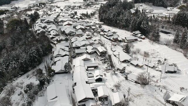 ドローンで空撮した冬の観光名所中参道の馬籠宿の古い町並みの雪景色
