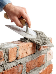 Closeup of hand holding trowel, applying mortar to brick wall, showcasing craftsmanship involved in masonry work. image captures texture and detail of materials used