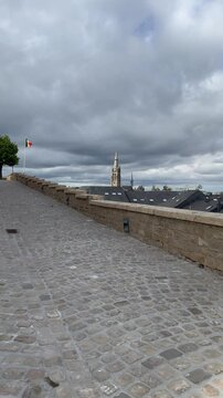 Panoramic, scenic skyline view of Arlon city buildings rooftops and Saint Martin church. Belgian flag is waving on top of Saint Donat church hill.  Arlon, Belgium