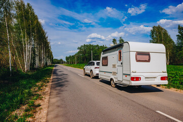 White caravan driving road on the way to the vacations. Beautiful camping holidays with a camping car. Family travel in Europe.