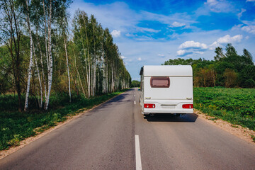 White caravan driving road on the way to the vacations. Beautiful camping holidays with a camping car. Family travel in Europe.