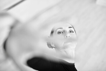 Young adult female ballerina with light hair captured reaching forward, creating dynamic motion....