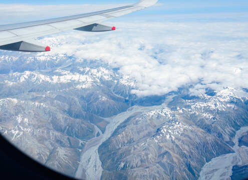 An airplane flying over Southern Alps and braided rivers. South Island. New Zealand. - Powered by Adobe