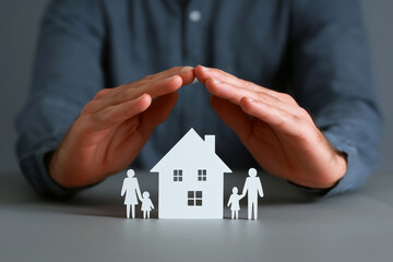 Two hands form a roof over a tiny paper family on a pure white backdrop, symbolizing protection and trust in a sleek, minimalist visual perfect for insurance or fintech branding.