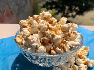 A bowl of popcorn on a blue surface